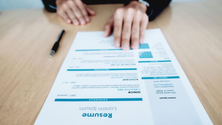 Uma pessoa está escrevendo em um papel com uma caneta