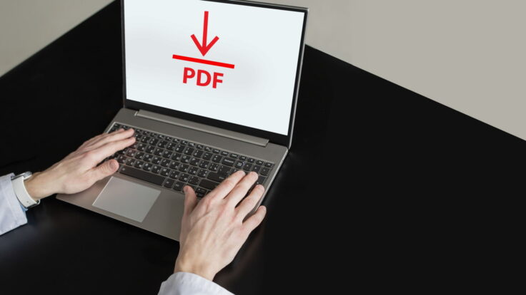 Um homem está digitando em um laptop com uma seta vermelha