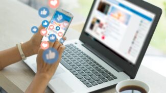 Uma mulher usando um laptop com ícones de mídia social.