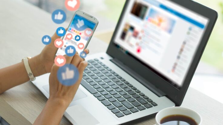 Uma mulher usando um laptop com ícones de mídia social.