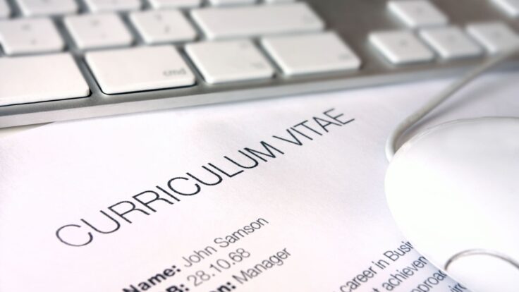Um mouse de computador fica em cima de um papel com a palavra curriculum vitae