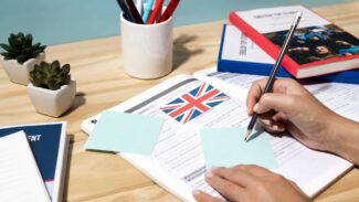 Uma pessoa escrevendo em um caderno com uma bandeira britânica