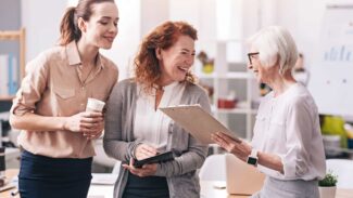 Três mulheres em um escritório conversando entre si