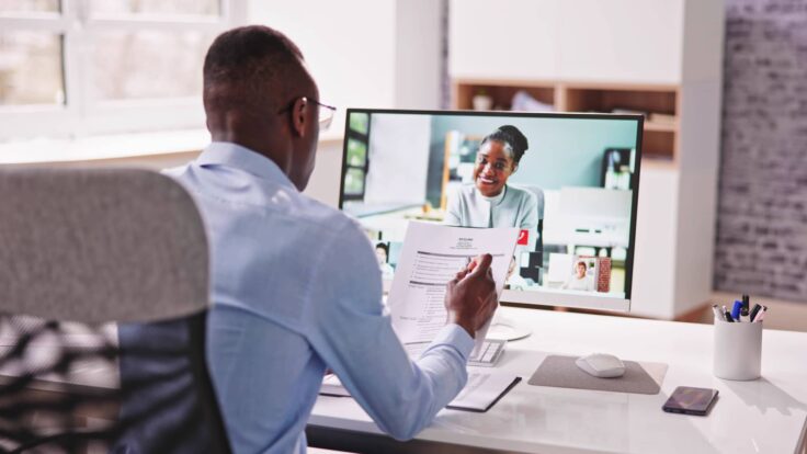 Um homem está usando um computador para fazer uma videochamada.
