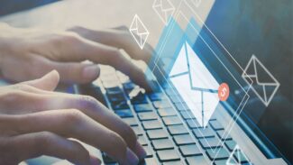 Uma pessoa digitando em um laptop com um ícone de e-mail
