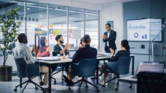Um grupo de empresários batendo palmas em uma reunião.